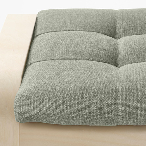 Close-up of a plush, light green textured fabric footstool, showcasing its comfortable, layered design.