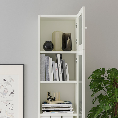 Librería BILLY blanca con puertas de cristal, expositora de jarrones decorativos y libros, libre de polvo.