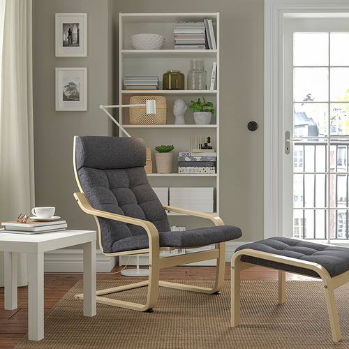Sillón POÄNG gris con estructura de madera cerca de la estantería y la ventana.