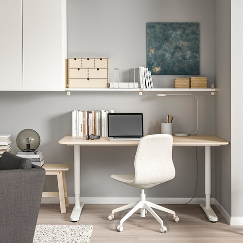 Configuración de oficina en casa con estante de pared BERGSHULT, silla blanca, escritorio de madera, obra de arte, libros y lámpara. Diseño minimalista.