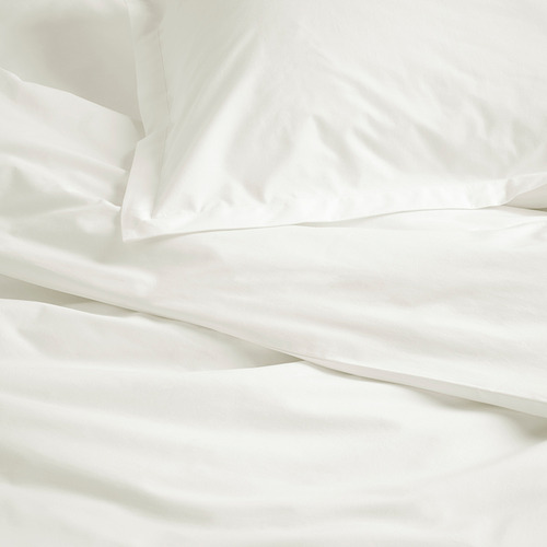 Ropa de cama de algodón blanco y nítido con costuras limpias y textura suave, que muestra un tejido de alta calidad.