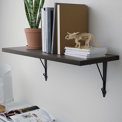 El estante de pared negro sostiene libros, plantas y decoración.