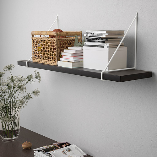 Estante de pared con estante negro y soportes blancos. Exhibiendo libros, cesta de mimbre y caja blanca. Acentuado con flores secas.