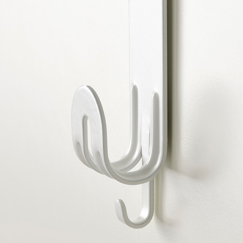 Gancho de metal blanco, montado de forma segura en una puerta, con tres puntas para colgar artículos.