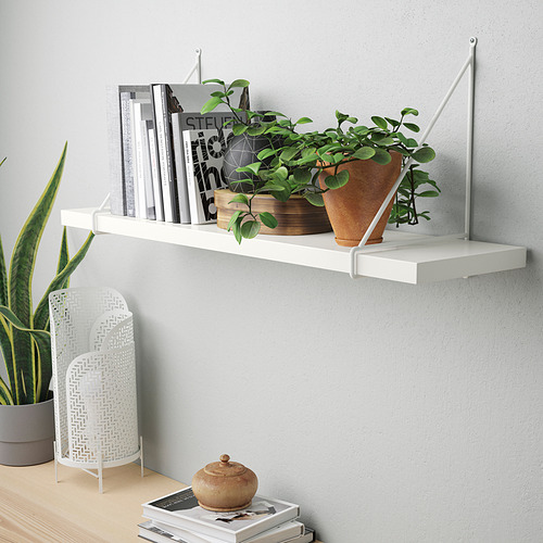 Estante de pared blanco con libros y plantas, que muestra la funcionalidad de exhibir artículos y transportar peso de manera uniforme.