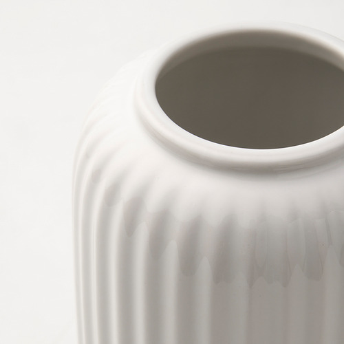 Jarrón blanco con superficie texturizada y acanalada, diseño limpio y minimalista.
