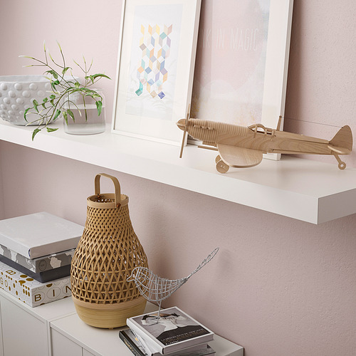 El estante muestra el modelo de avión, la planta, la cesta y los libros. Artículos de almacenamiento minimalistas.