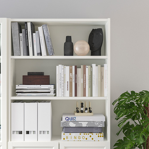 Estantería con estantes ajustables, que exhiben libros, artículos decorativos y juegos de mesa, organizados ordenadamente.