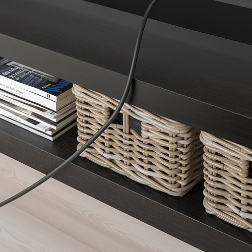 Mueble de tv minimalista NEGRO con cestas tejidas y libros apilados. Gestión de cables visible.
