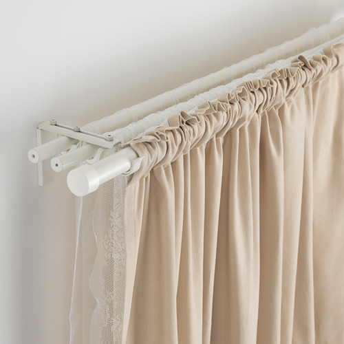 Barra de cortina ajustable blanca con cortinas beige.