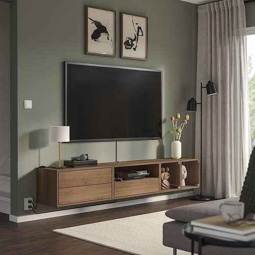 Sala de estar moderna con paredes verdes, TV de pantalla plana, consola de madera con decoración, ventana con cortinas y silla gris.