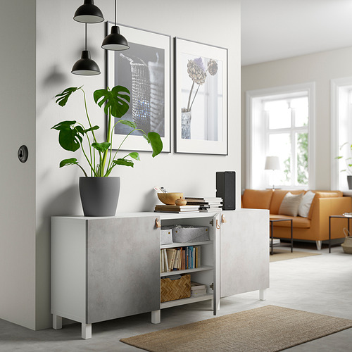 Sala de estar moderna con almacenamiento BESTÅ, planta, sofá naranja.