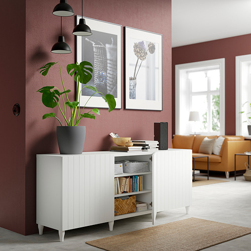 Sala de estar moderna con estantes BESTÅ, libros, plantas, debajo de la pared granate.