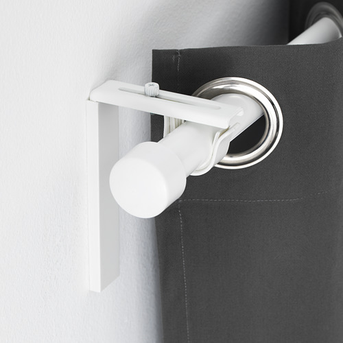 Soporte de barra de cortina ajustable blanco montado en pared gris oscuro, sosteniendo barra de cortina plateada, lo que demuestra versatilidad en la colocación de cortinas.