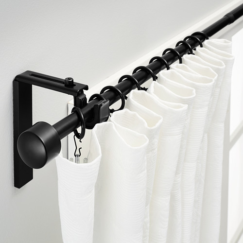 Barra de cortina negra en pared con cortinas blancas, longitud y ángulo ajustables.