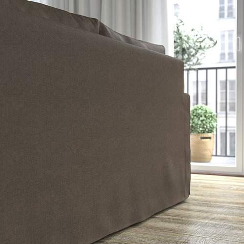 Sofá gris junto a ventana, confort con cojines reversibles.