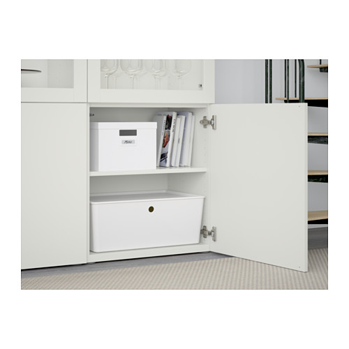 Gabinete blanco con estantes, cajas de almacenamiento y puertas de vidrio. Las bisagras permiten el ajuste de la puerta. Bisagras de cierre suave visibles.