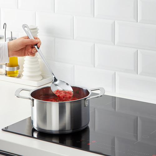 Cocine la salsa roja revolviendo en una estufa moderna.
