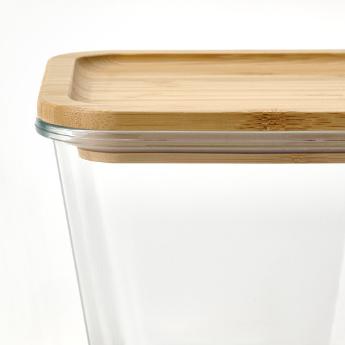 Recipiente de vidrio transparente con tapa de bambú, sellado con silicona.