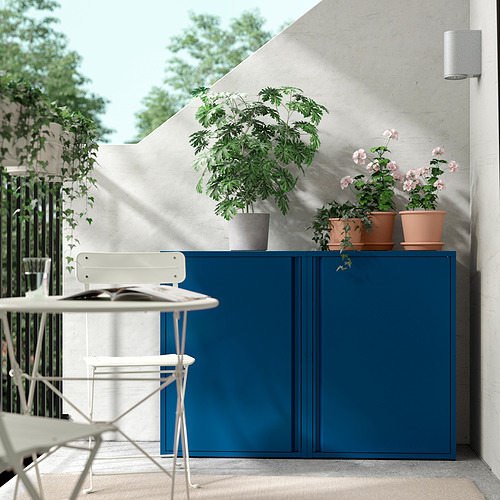 Escena de balcón con mueble SUNDSÖ azul, plantas en macetas y sillas blancas.