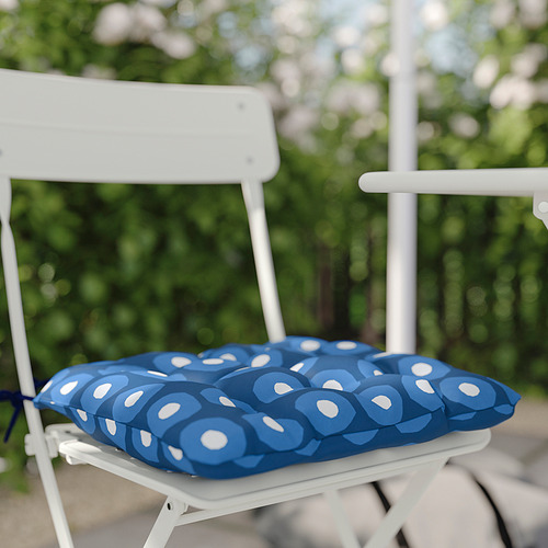 Silla de metal blanco con cojín azul de estampado circular en el exterior.