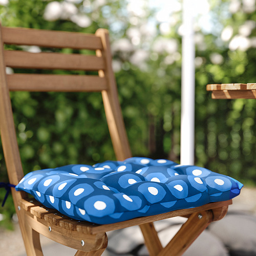 Silla de madera con cojín azul de estampado circular en el exterior.