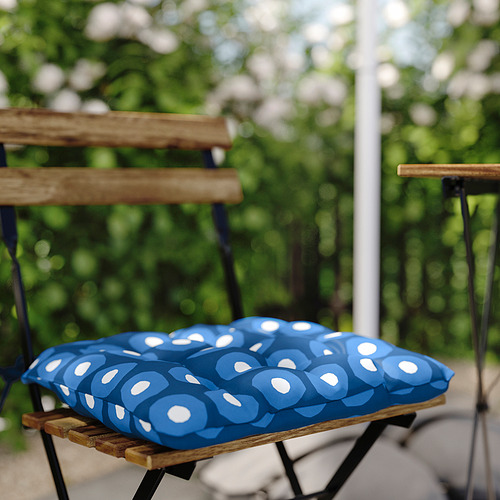 Silla de exterior acolchada azul con asiento de madera y patas metálicas, estampada con lunares blancos.