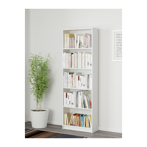 Estantería blanca con libros, plantas y obras de arte.