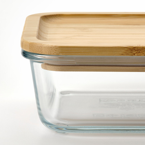 Recipiente de vidrio transparente para alimentos con tapa de bambú, ideal para almacenar y servir comidas.