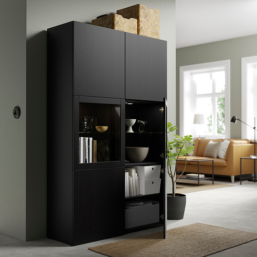 Armario BESTÅ negro con puertas de cristal, elementos decorativos que ocultan el desorden. Estantes y puertas ajustables con bisagras de cierre suave.