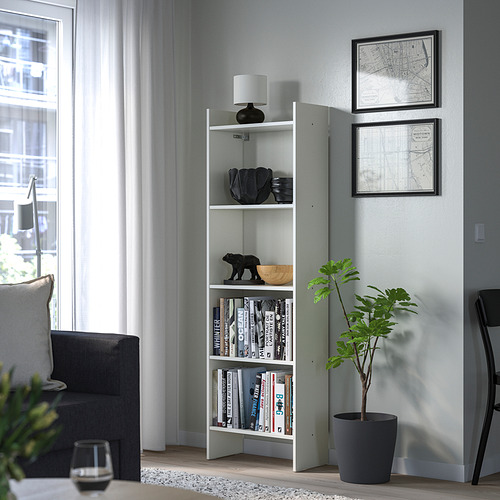 Estantería minimalista blanca BAGGEBO con lámpara, libros y decoración en el salón.