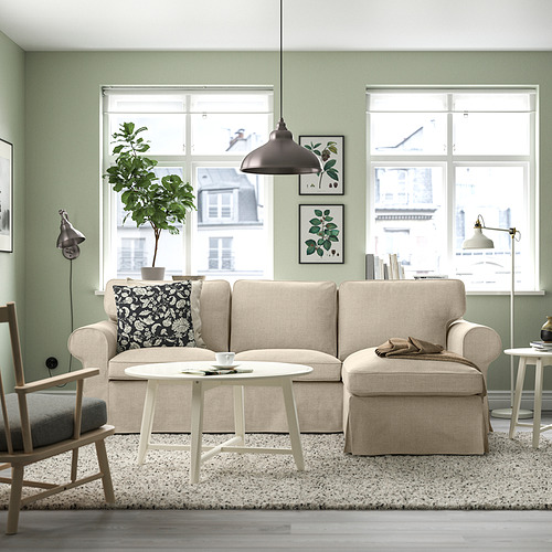 Sala de estar moderna con sofá beige EKTORP, grandes ventanales, paredes verdes, planta, mesa de centro, lámpara colgante. El sofá es de gran tamaño, céntrico.