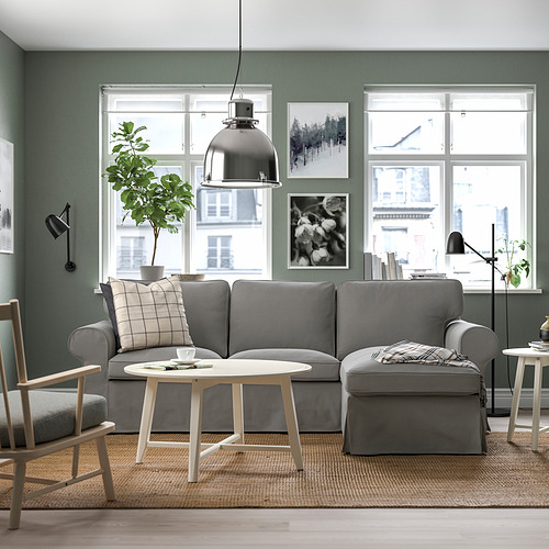 Sala de estar moderna con sofá EKTORP gris, gran ventanal, luz natural, ambiente vegetal, decoración minimalista. El sofá encaja perfectamente debajo de los grandes ventanales.