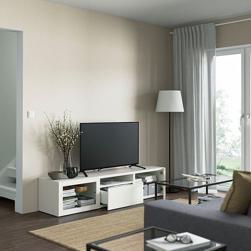 Sala de estar moderna con banco de TV BESTÅ blanco, TV de pantalla plana, frentes de cajones de vidrio, pies ajustables y administración de cables.