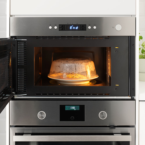 Horno microondas incorporado con pantalla digital y un plato calefactor en el interior cubierto con tapa.