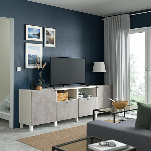 Banco de tv BESTÅ gris con tv, lámpara, arte enmarcado, mesa de centro negra, iluminación suave.