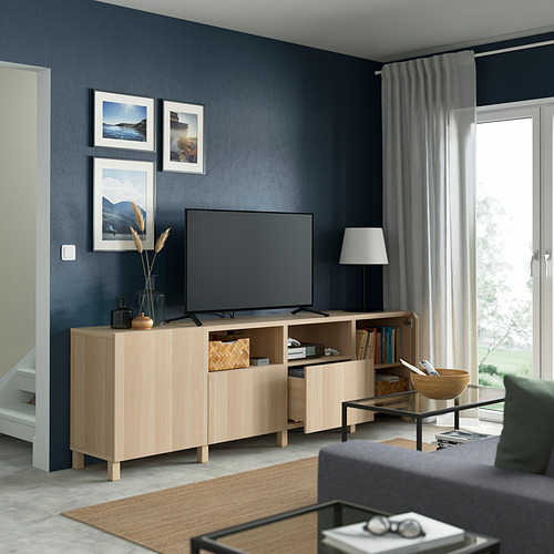 Sala de estar moderna con paredes azul oscuro, mueble de TV BESTÅ, estantes ajustables, TV de pantalla plana, ventana grande.