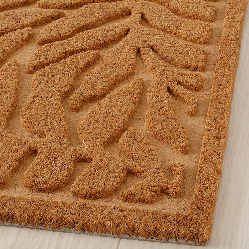 Felpudo con patrón de hojas en relieve, fibras de coco, superficie texturizada en 3D.