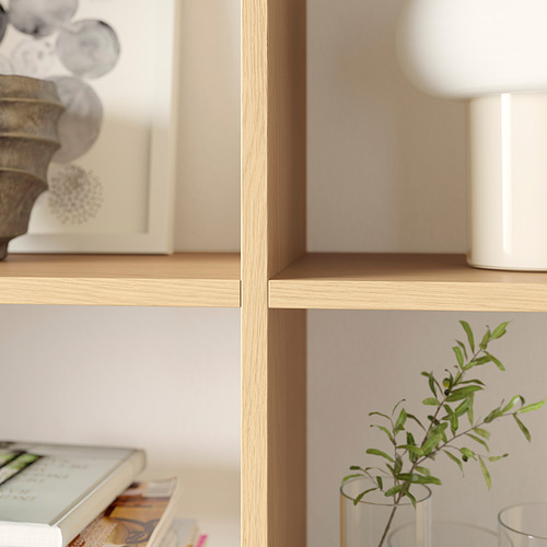 Instalación de estantes de madera ligera que contienen varios artículos de decoración para el hogar como jarrones y una planta.