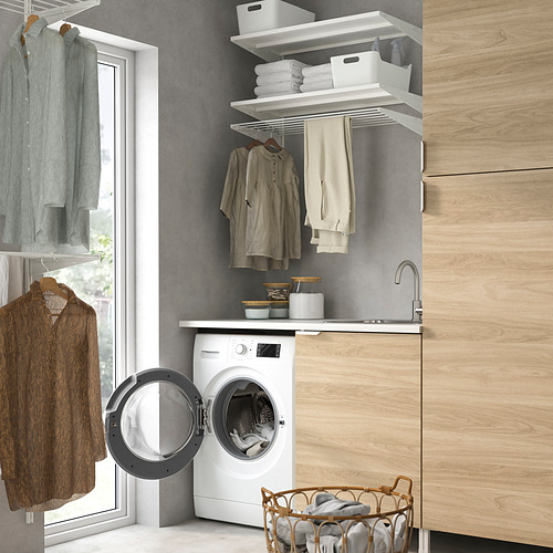 Moderno lavadero con electrodomésticos UDDARP, gabinetes, fregadero, almacenamiento y ropa doblada.