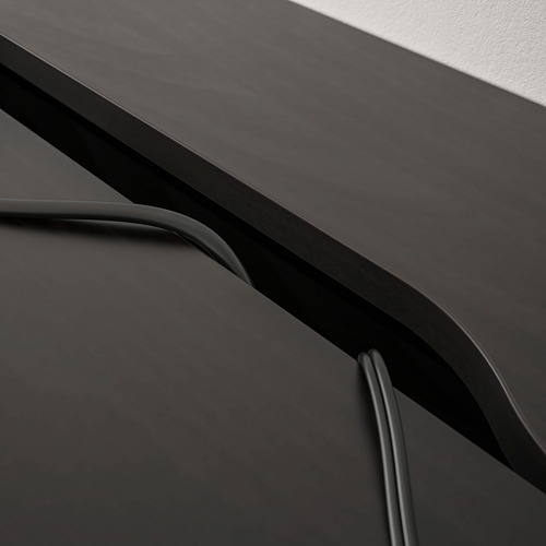 Escritorio moderno con un diseño elegante y minimalista; Gestión de cables incorporada y cajones de almacenamiento visibles.