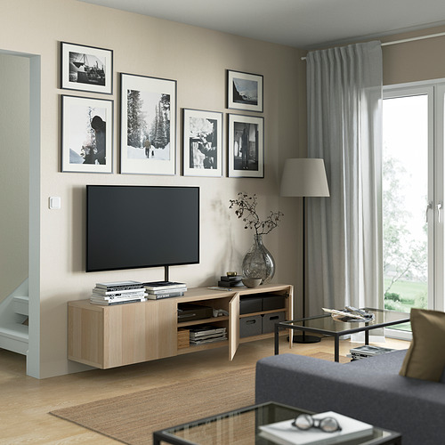 Sala de estar moderna con banco de televisión BESTÅ, TV de pantalla plana, almacenamiento y pared de galería.