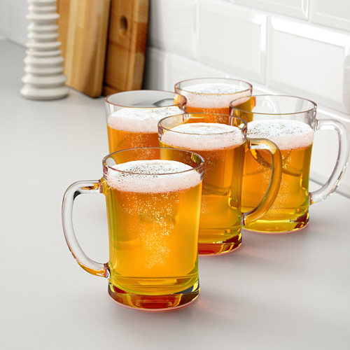 Cuatro vasos de cerveza con espuma en el mostrador.