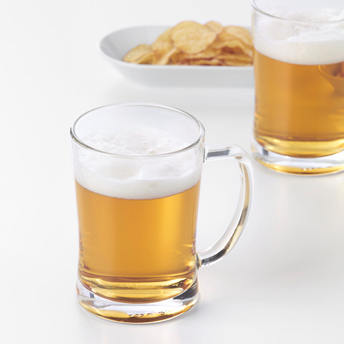 Dos jarras de cerveza con una cabeza generosa, colocadas junto a un bol de aperitivos. La forma contiene sabores y aromas, mejorando la experiencia de beber.