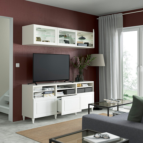 Sala de estar moderna con mueble de TV BESTÅ, TV de pantalla plana y sofá gris. Elementos decorativos y soluciones de almacenamiento a la vista.