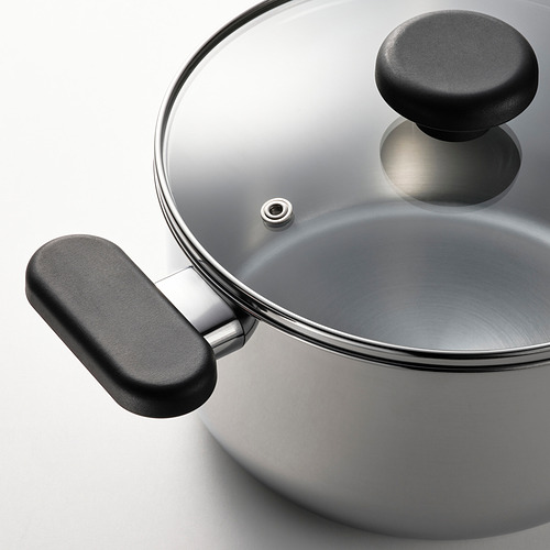 Cacerola moderna de acero inoxidable con tapa de vidrio, asas negras, lista para cocinar.