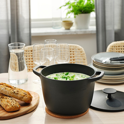 Mesa de comedor con sopa, pan y cubiertos.