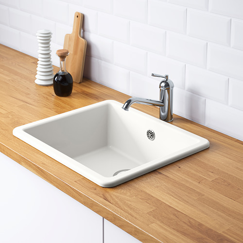 Fregadero HAVSEN blanco con grifo plateado sobre encimera de madera, incluyendo trampa de agua y colador.