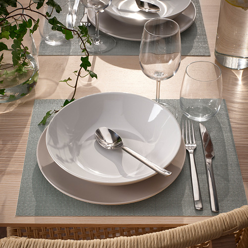 Puesta de mesa con manteles individuales, platos y cubiertos FLYGFISK, listos para comer.