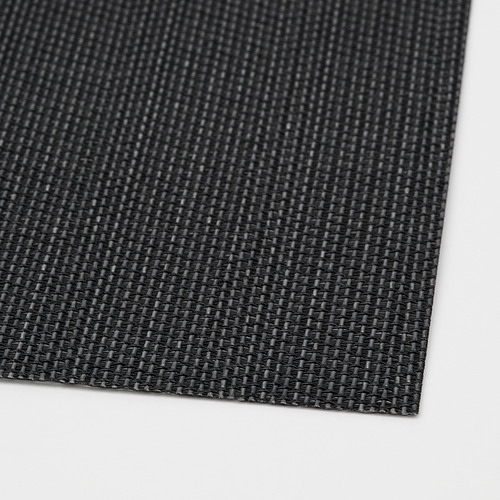 Primer plano del mantel individual de plástico negro tejido, que muestra su superficie texturizada y duradera.